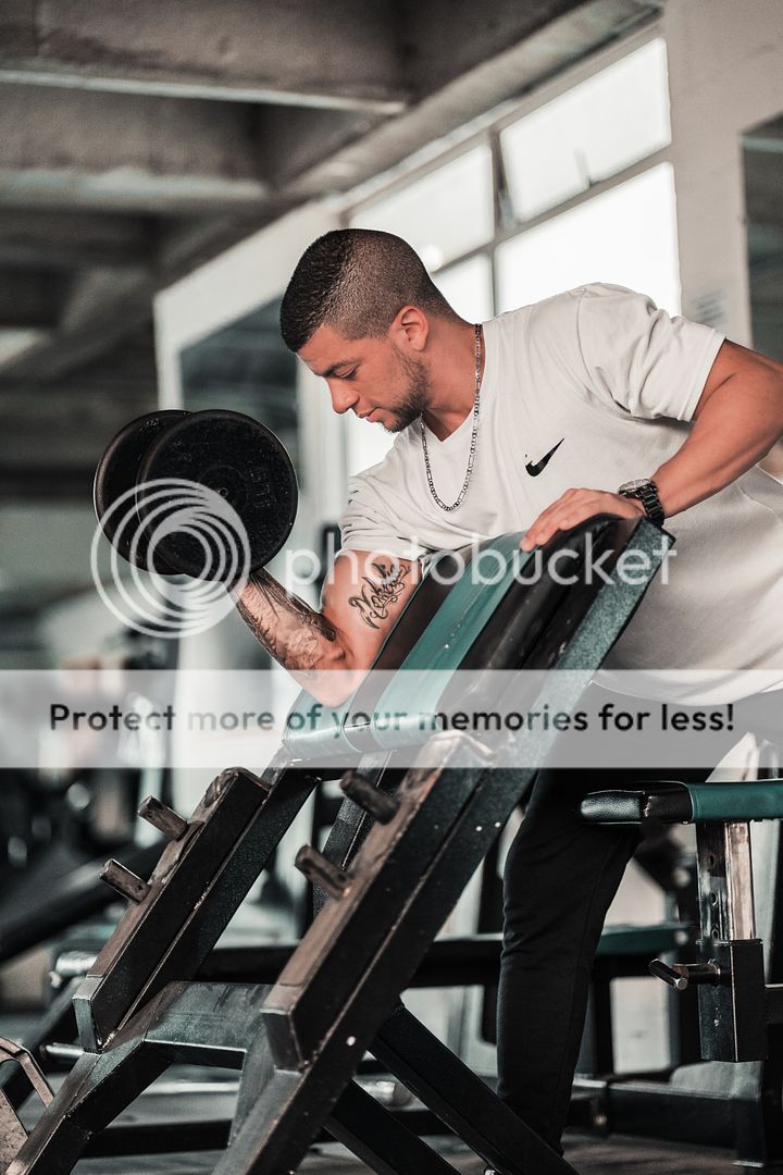 man lifting a dumbbell in a gym
